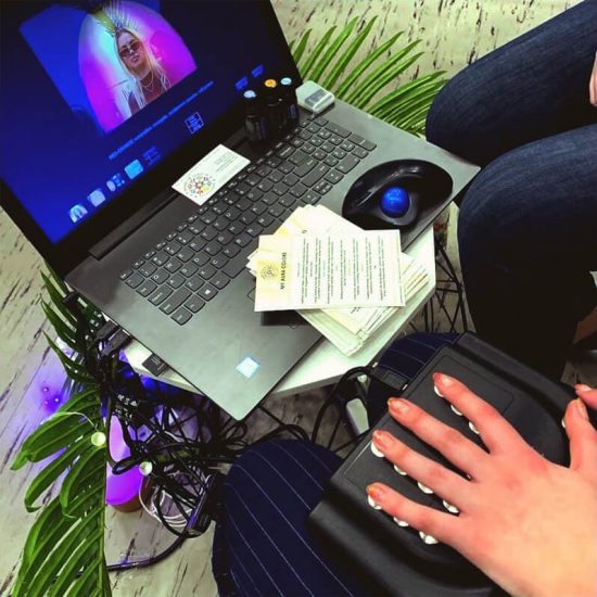 live photo of hand sensors producing an aura visualization on a laptop screen